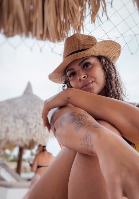 Michelle under a palapa at the beach in a straw hat
