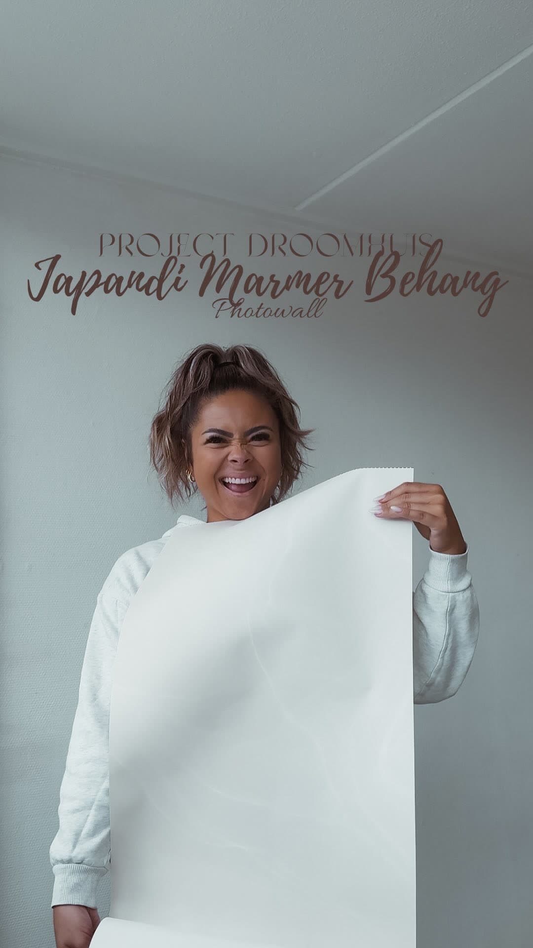 Michelle with a roll of Japandi marble wallpaper